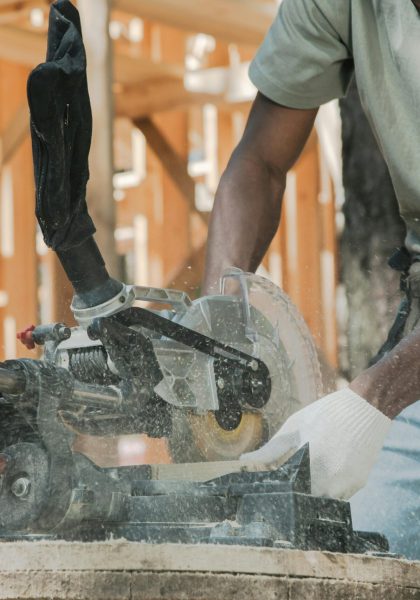Action shot of a carpenter using a circular saw outdoors, demonstrating precise craftsmanship.